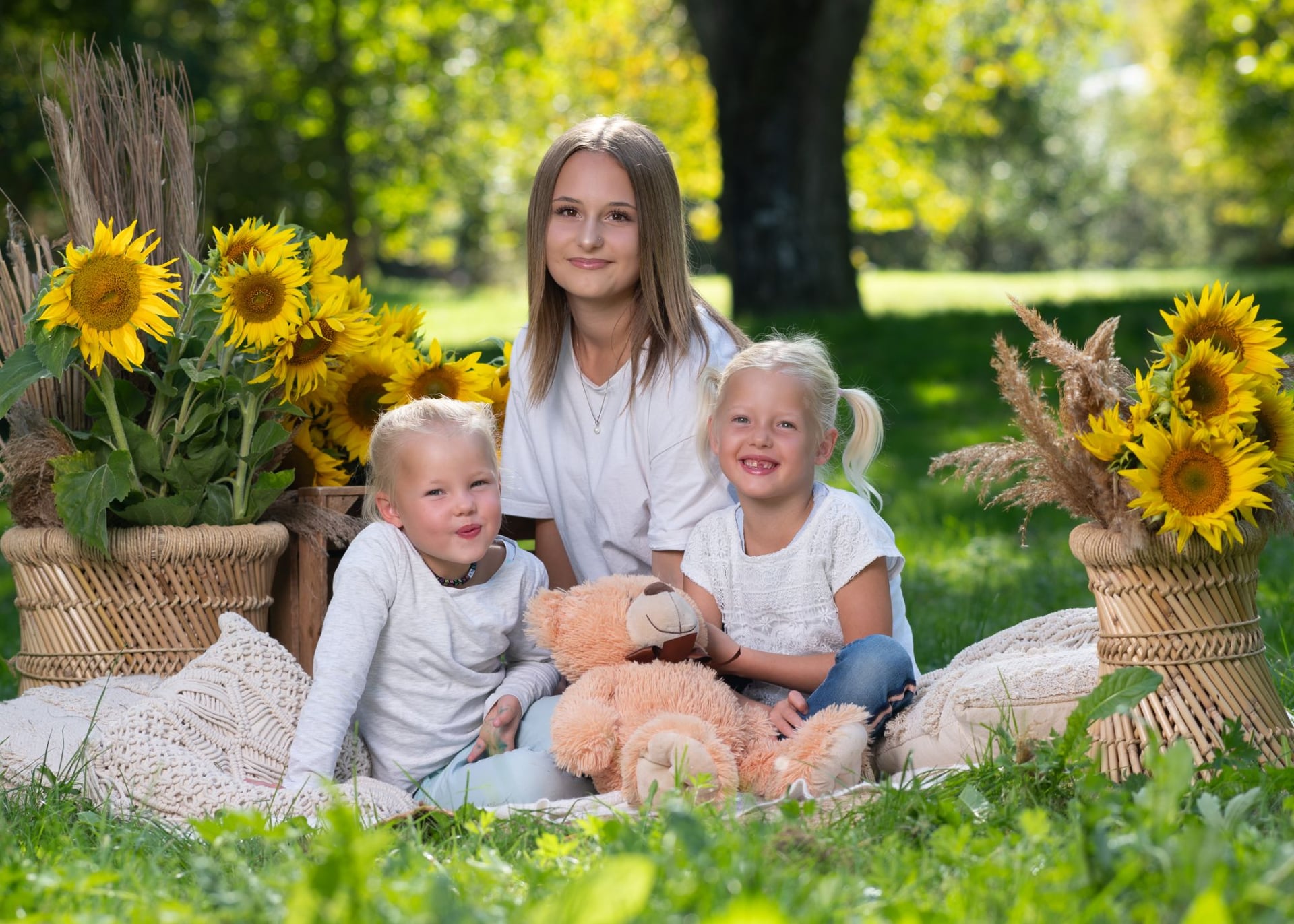 Drei Schwestern auf einer Picknickdecke im Park