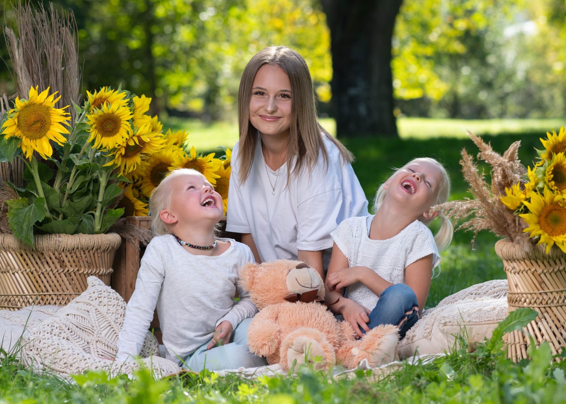 Drei Schwestern lachen zwischen Sonnenblumen