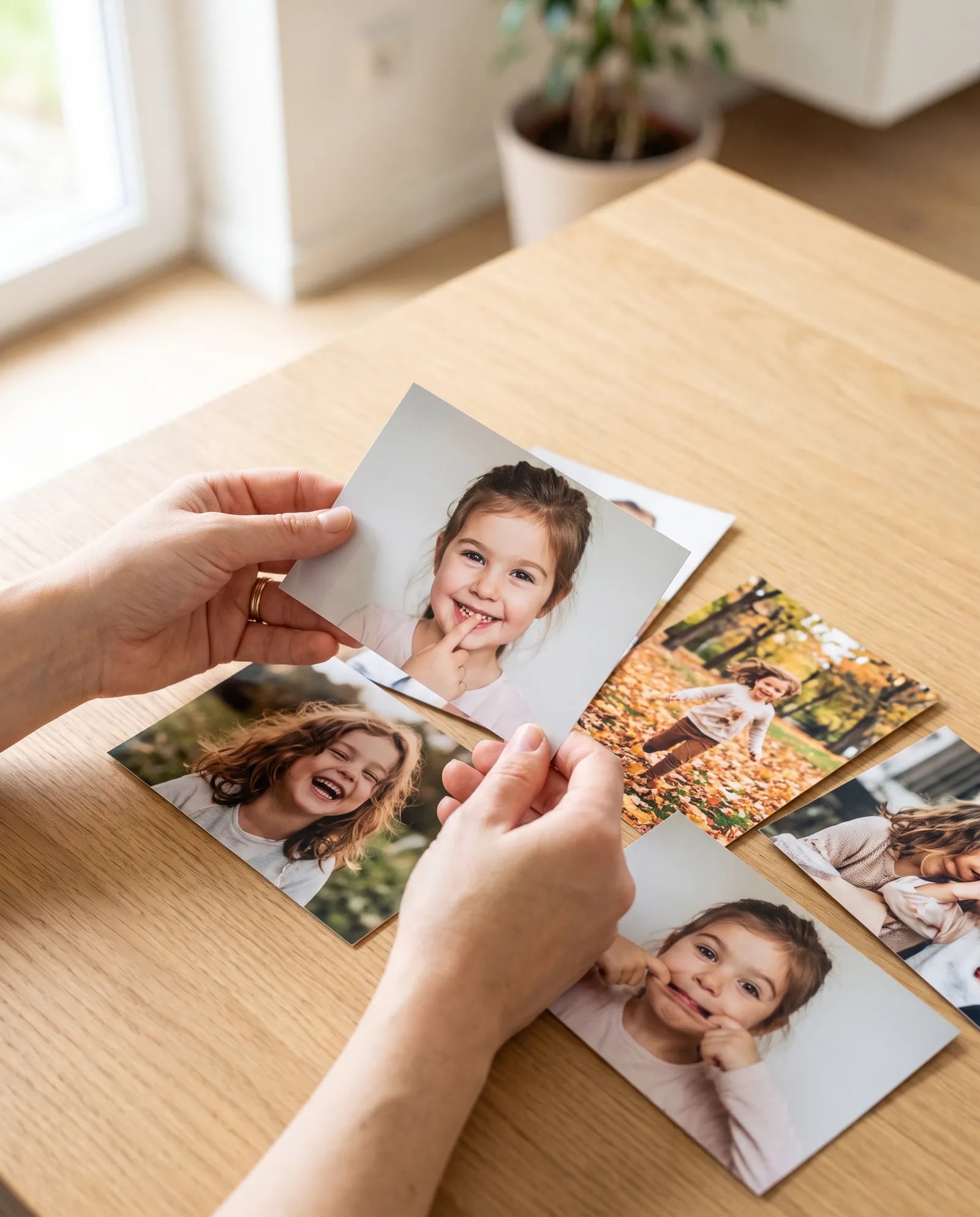 Hand hält gedruckte Kinderfotos